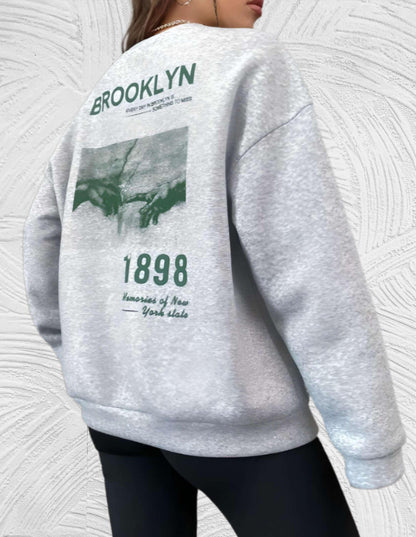 Sheryll - Oversized trui met ronde hals eenvoudige voorkant met Brooklyn 1898 statement en foto ontwerp aan de achterkant - Miller-Mode