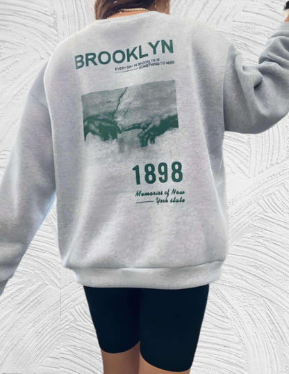 Sheryll - Oversized trui met ronde hals eenvoudige voorkant met Brooklyn 1898 statement en foto ontwerp aan de achterkant - Miller-Mode