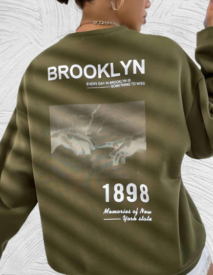 Sheryll - Oversized trui met ronde hals eenvoudige voorkant met Brooklyn 1898 statement en foto ontwerp aan de achterkant - Miller-Mode